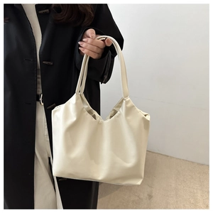 Detail of off-white minimalist tote bag in soft PU leather held by hand for daily use