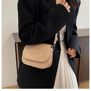 Detail of minimalist beige crossbody square bag with fashion trend lettering on blazer