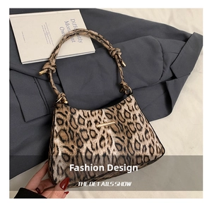 Dettaglio borsa baguette leopardata con tracolla annodata e finiture in metallo dorato