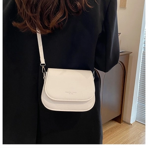 Detail of off-white PU leather saddle bag with Fashion Trend logo shown on a model