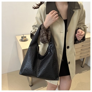 Gros plan d'un grand sac cabas hobo en cuir tressé noir avec détails de texture fins