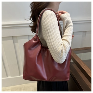 Model wearing a deep red minimalist oversized tote bag showing scale and soft texture