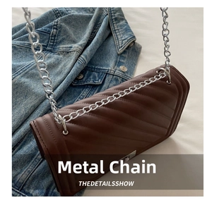 Close-up of brown quilted shoulder bag with diagonal stitching and silver chain strap