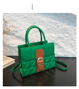 Détail du sac bandoulière matelassé vert avec grande boucle fer à cheval dorée et poignée