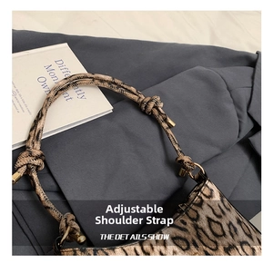 Dettaglio della tracolla annodata regolabile con fibbia dorata sulla borsa leopardata