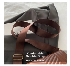 Detail of comfortable wide nylon shoulder strap and vintage metal buckle on brown bag
