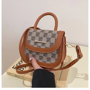 Detailed view of the saddle bag showing brown leather stitching and golden metal buckle