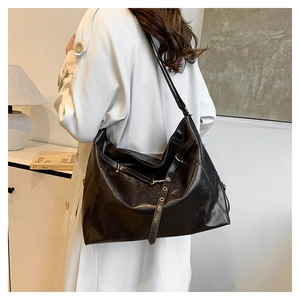 Vintage brown leather hobo bag with large capacity, shown on model for daily commute