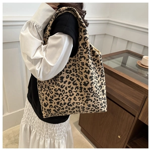 Détail d'un sac cabas en velours côtelé léopard porté par un mannequin stylé