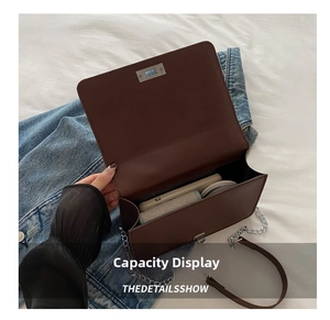 Internal capacity view of brown chain crossbody bag showing phone and cosmetics