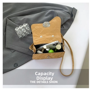Interior view of khaki crossbody bag showing storage for phone, lipsticks and earphones