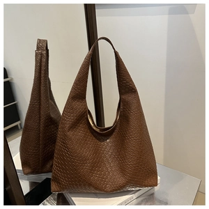 Détail de la texture en cuir tressé marron foncé de ce grand sac fourre-tout hobo