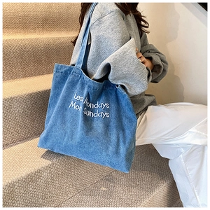 Detail of white 3D embroidery text on vintage blue denim canvas tote bag for school