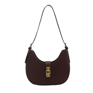 Minimalist burgundy crescent shoulder bag with golden metal ring buckle on white background