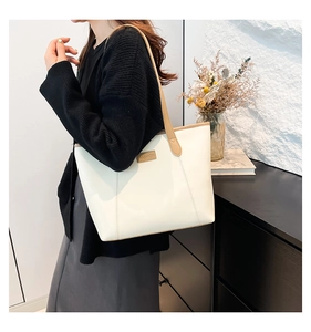Détail du grand sac cabas en cuir blanc avec étiquette FASHION et fines anses brunes