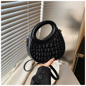 Detail of black croc-pattern half-moon bag with gold hardware and round handle