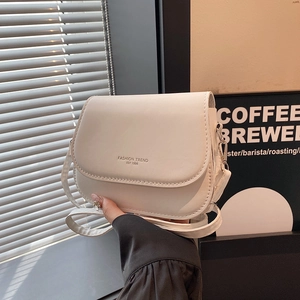 Minimalist white semi-circle saddle shoulder bag with elegant flap design and strap