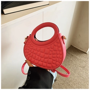 Macro shot of bright pink crocodile embossed texture and round hollow handle on the bag