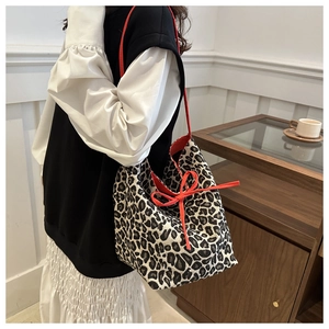Model showing leopard print canvas tote bag with red drawstring bow and large capacity