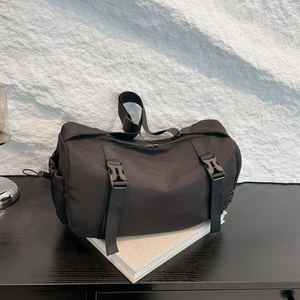 Minimalist black nylon cylinder crossbody bag with buckle straps and large capacity