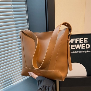Minimalist brown leather bucket bag with large capacity and stylish wide shoulder strap