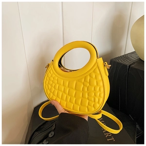 Close-up of bright yellow PU leather half-moon bag with gold metal ring handle