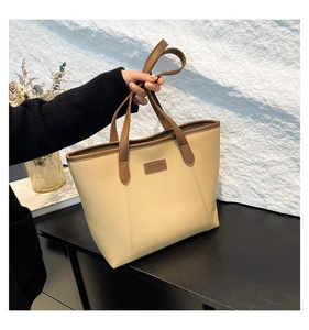Gros plan du sac cabas en similicuir beige et marron avec étiquette FASHION gravée