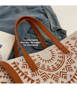 Detail view of woven canvas tote bag with geometric sun pattern and leather handles