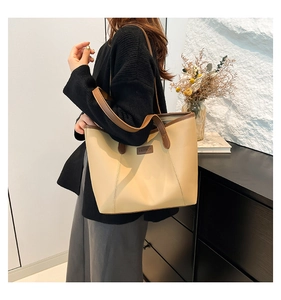 Gros plan d'un grand sac cabas beige avec brides marron et étiquette en cuir sur un mannequin