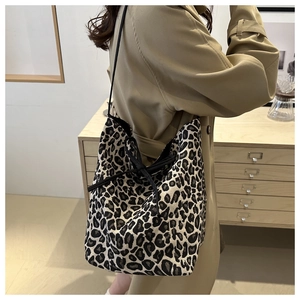 Detail of large leopard print tote bag with black bow tie strap for daily commute