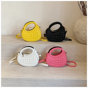 Quilted crescent handbags in yellow black white and pink on minimalist stone steps