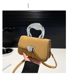 Detailed shot of brown embossed leather handbag with unique silver liquid metal handle