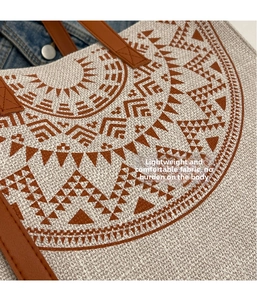 Close-up of woven tribal tote bag fabric with red geometric pattern and leather handle