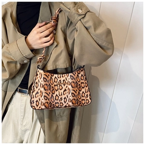 Detail of leopard print shoulder bag featuring textured fabric and knotted strap