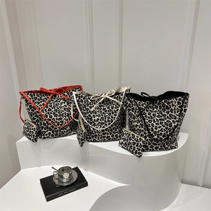 Leopard print canvas tote bag set with bow tie closure on artistic display stand