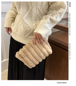 Detailansicht der beigen Plüsch-Clutch mit horizontalen Falten für den Winter