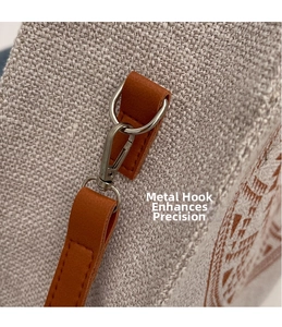 Detailed close-up of grey beige tote bag with silver metal hooks and brown leather accents