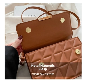 Detail of the high-quality gold magnetic clasp on a brown quilted PU leather handbag