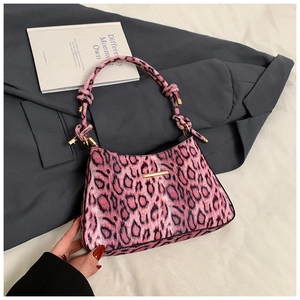 Detail of pink leopard print shoulder bag with gold hardware and knot handle design