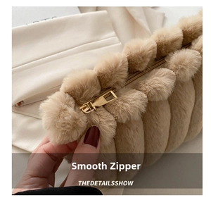 Détail de la fermeture éclair dorée sur une pochette en fausse fourrure beige doux