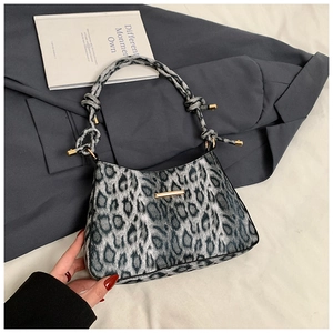 Detail of leopard print shoulder bag featuring gold hardware and a knotted strap design