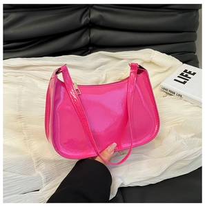 Detail of fuchsia patent leather hobo bag with glossy finish and golden metal zipper