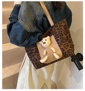 Detail of leopard print tote bag featuring a 3D plush bear and light beige front pocket