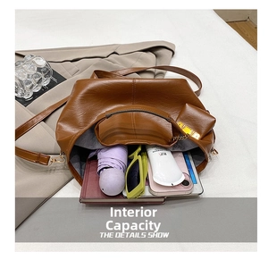Macro view of brown leather bucket bag showing large capacity with umbrella and tablet inside