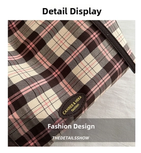 Close-up of pink and brown plaid canvas fabric with a branded leather patch detail