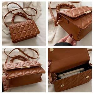 Detail view of brown quilted crossbody bag with pleated handle and magnetic closure