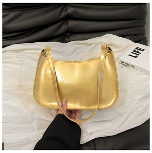 Detail of metallic gold shoulder bag showing shiny mirror-finish leather and strap