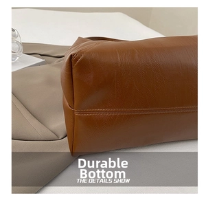 Detail showing the wear-resistant bottom and double stitching of the brown leather tote bag