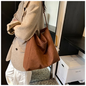 Detail of caramel brown tote bag in textured matte leather showing large capacity