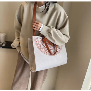 Detail of large canvas tote bag with geometric print and brown faux leather straps